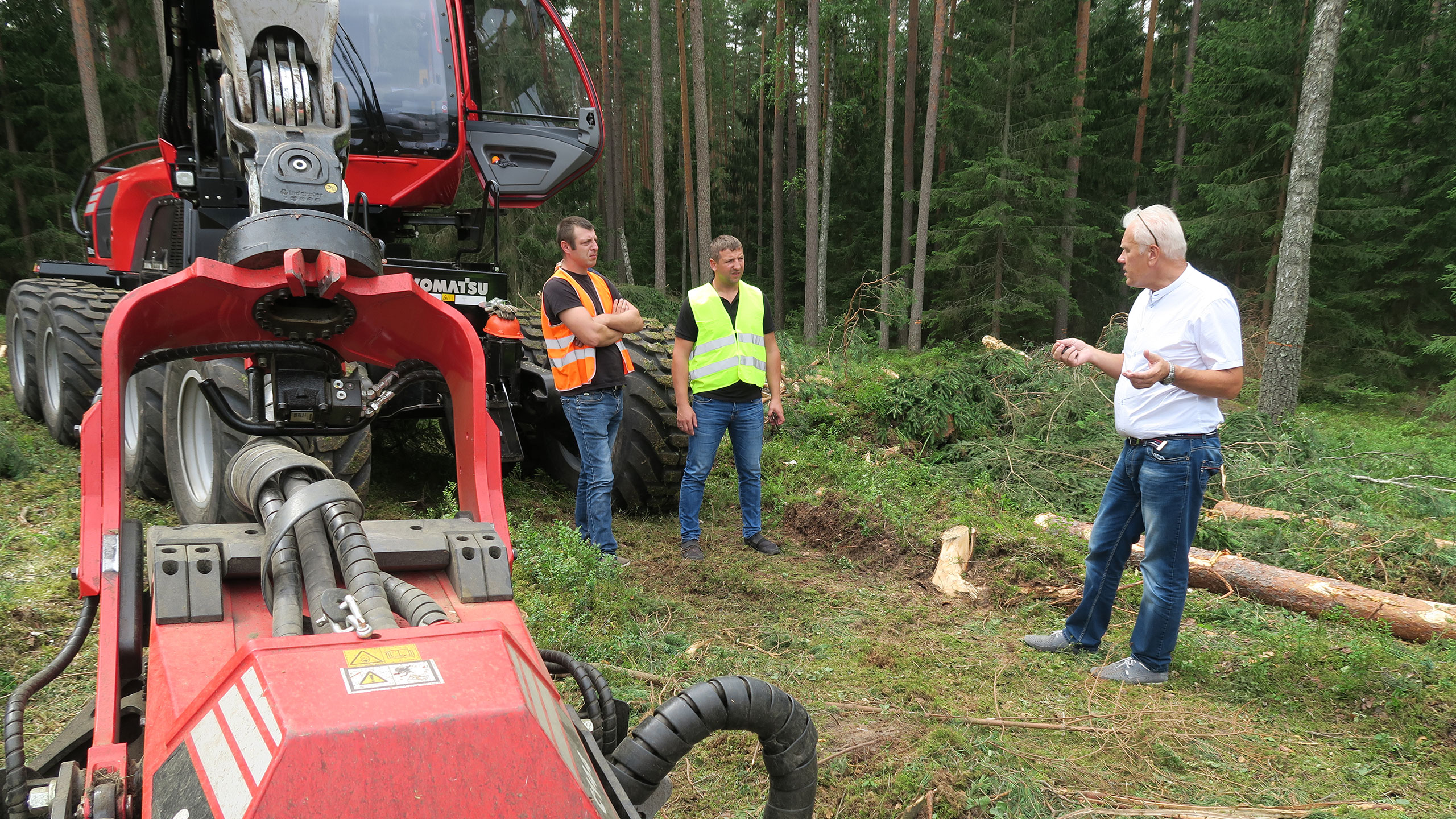 Švenčionėliain alueen Komatsu 931XC:n kuljettaja (vas.) keskustelee DOJUS agron metsäkonehuollon päällikkö Edgaras Jakštas sekä Metsähallituksen puunkorjuuyksikön päällikkö Vigantas Kraujalis